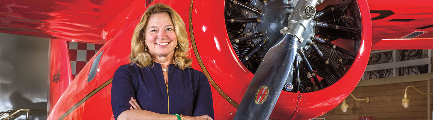 A woman standing in front of a plane at a museum